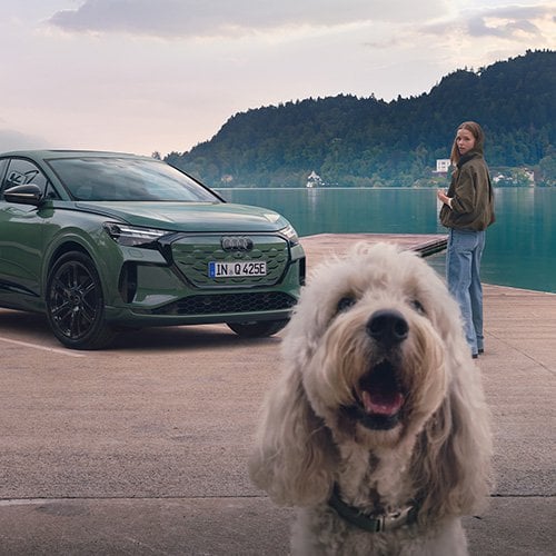 Un femme et son chien devant une Audi Q4 E-Tron