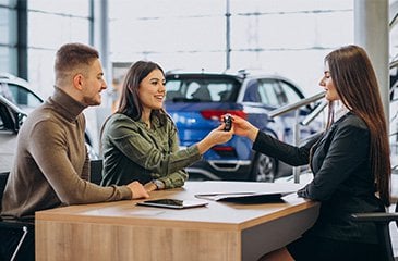 Un couple qui achète une voiture d'occasion dans une concession Cobredia