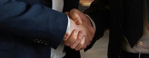 Business partners shake hands, making a deal.